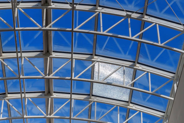 Broken glass on the roof of the building. Blue sky. Dirty windows. Inside view.